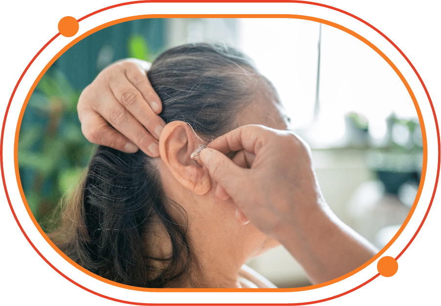 Mature woman getting her hearing aid fitted